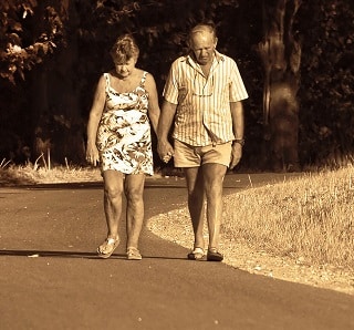 Elder couple walking on road in summer clothes